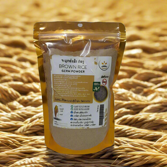 A sealed, yellow-colored zip-lock bag of Brown Rice Germ Powder, with product information and branding visible on the label, set against a background of woven mats.