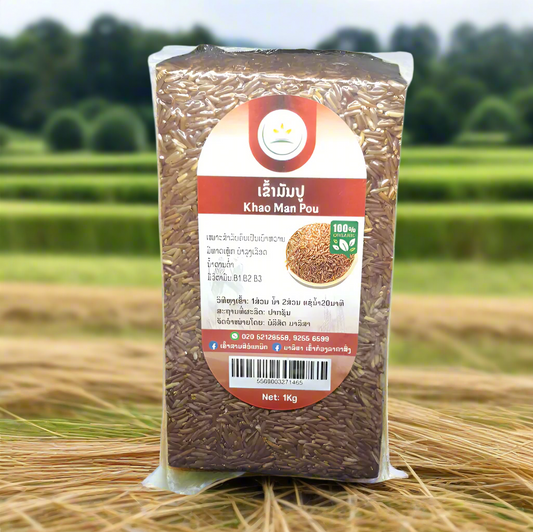 A pack of Khao Man Pou organic rice in a clear plastic bag, with a green label displaying the brand, product name, and additional information, set against a natural background.
