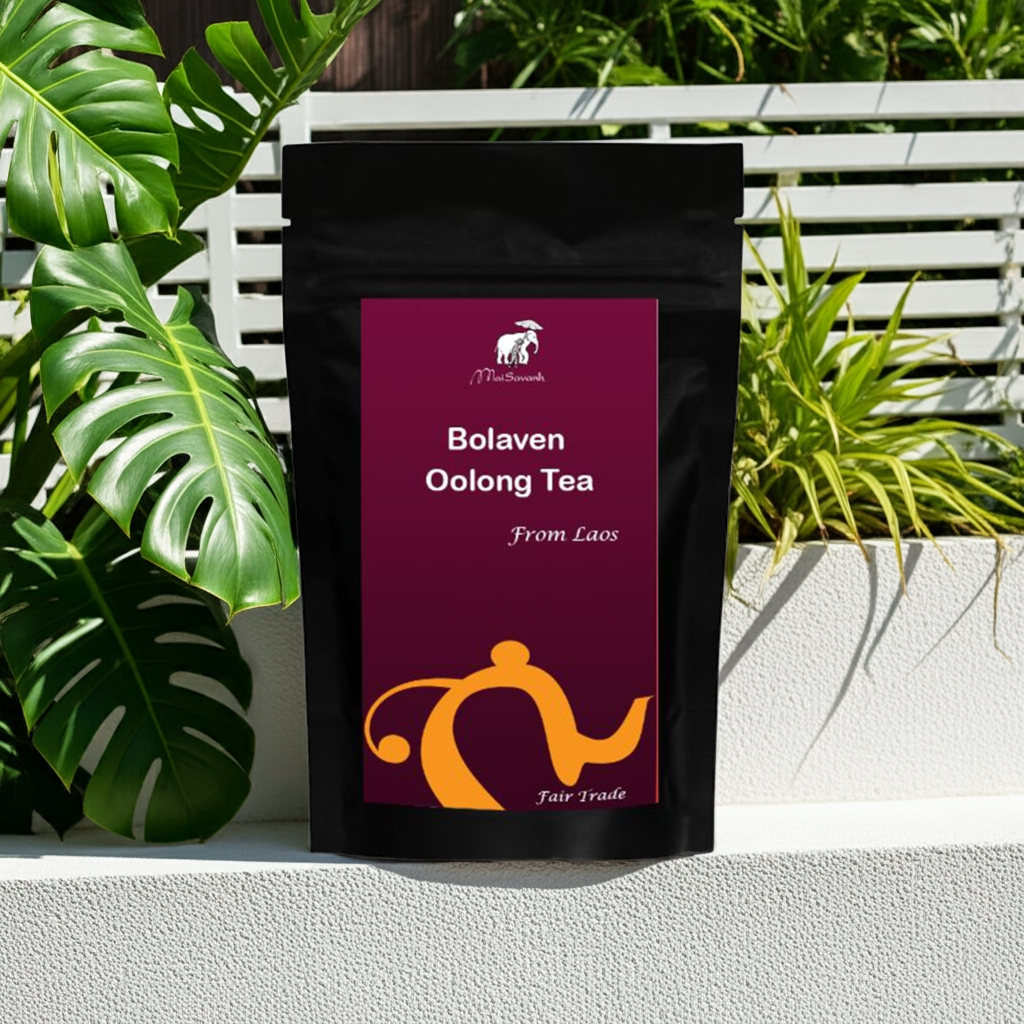 Tea bag labeled 'Bolaven Oolong Tea From Laos' with a brand logo, set against a natural background with plants.