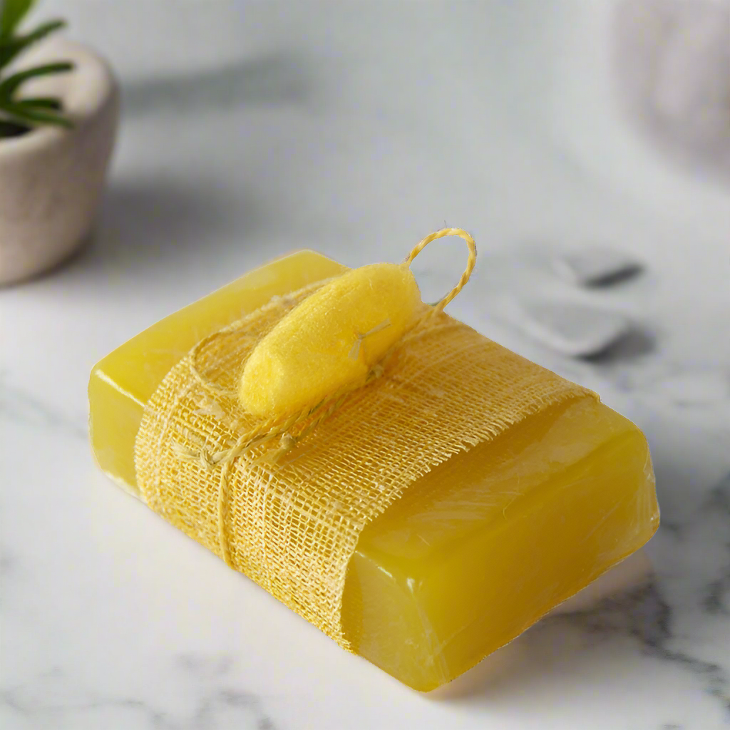 A bar of yellow soap wrapped in brown paper with a yellow string, placed on a white marble surface.