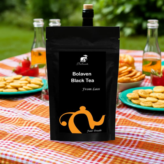 Bolaven Black Tea package on a table with snacks and drinks