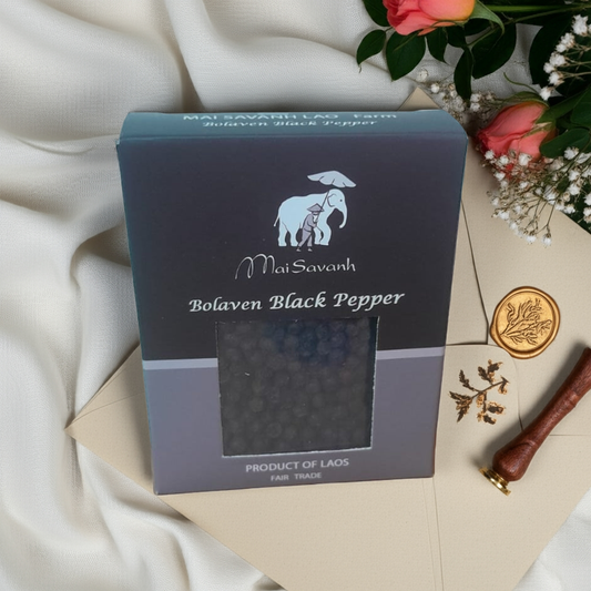 Mai Savanh Bolaven Black Pepper packaging on a decorative background with flowers and a letter.