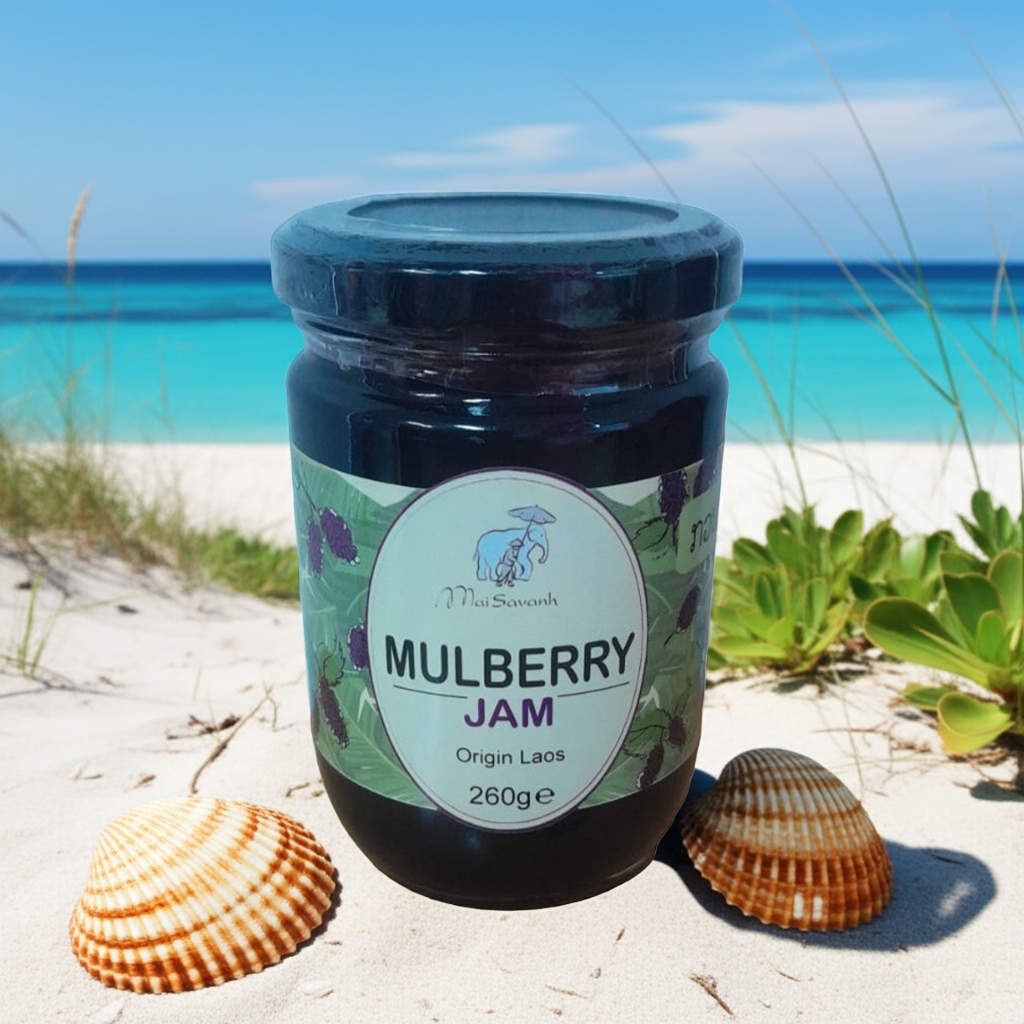Jar of mulberry jam on a sandy beach with seashells and ocean view