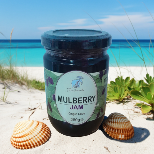 Jar of mulberry jam on a sandy beach with seashells and ocean view