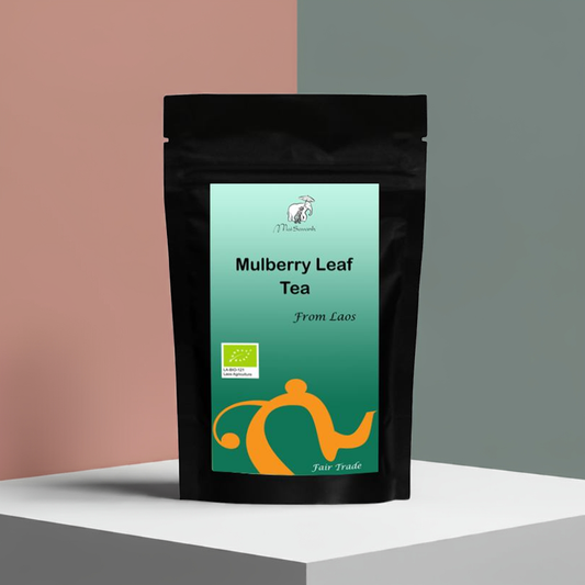 Black tea bag with green label on a multicolored background