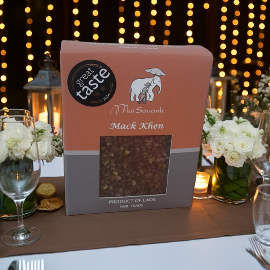 Mack Khen package on a table with decorative lights and flowers